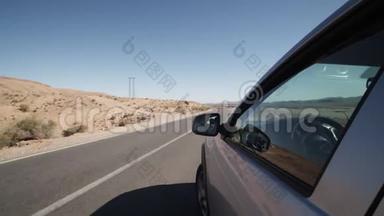 慢速行驶：在阳光明媚的天气里，在银色车窗外行驶在干燥的陆地上